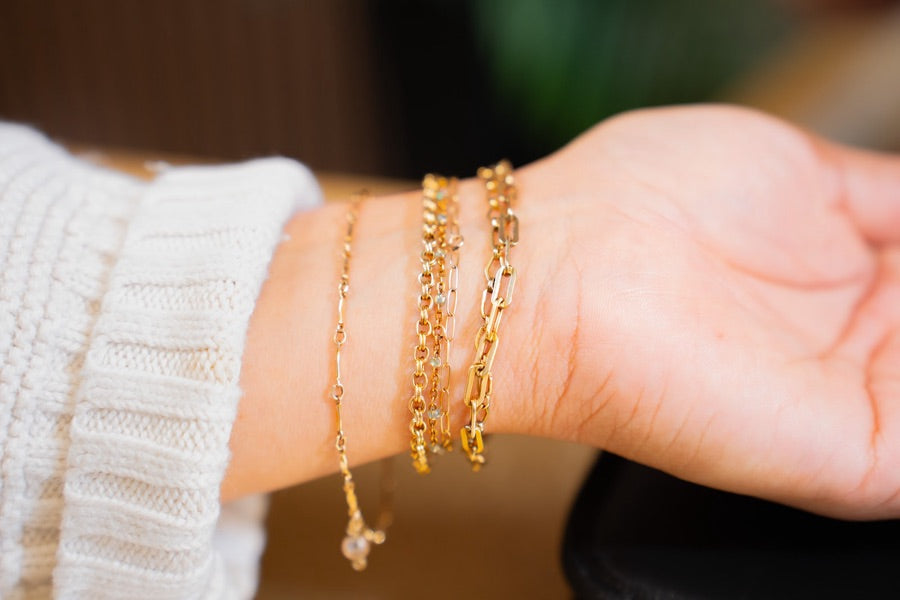 A finished stack of gold permanent jewelry bracelets